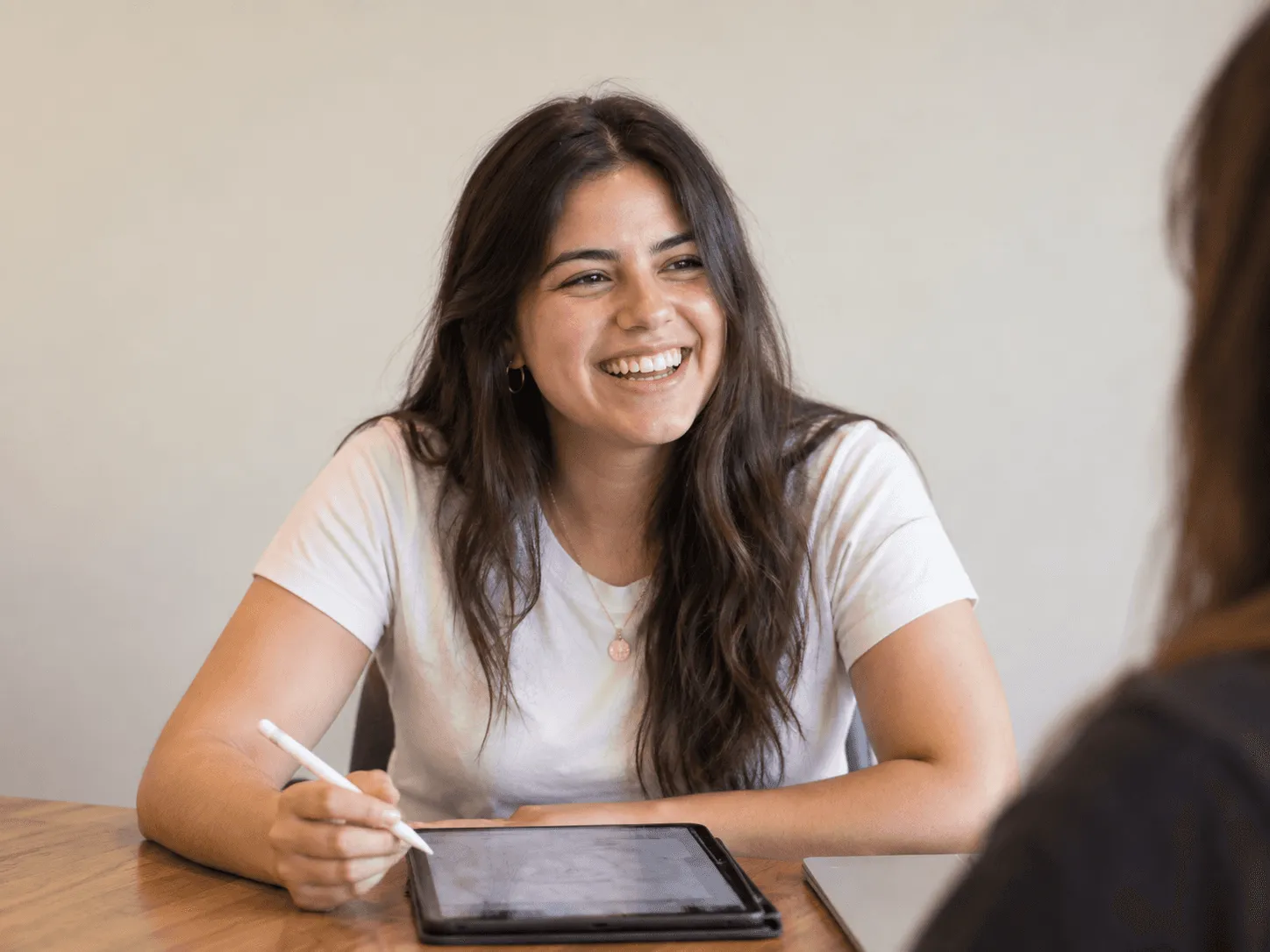 Estudiante sonriendo mientras trabaja en una tablet