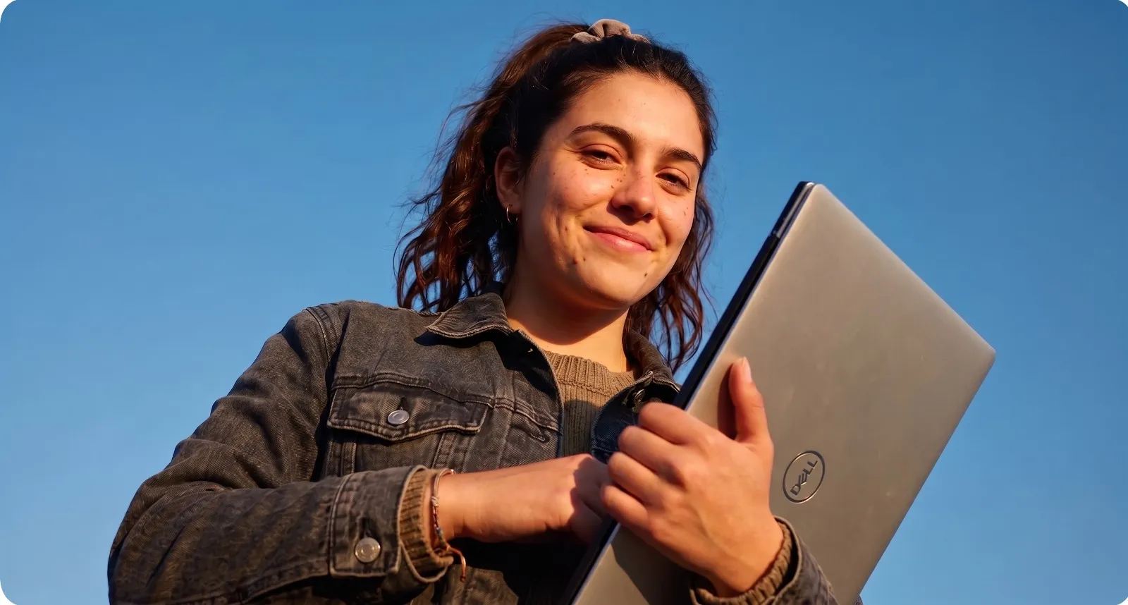 Estudiante con un computador, al aire libre