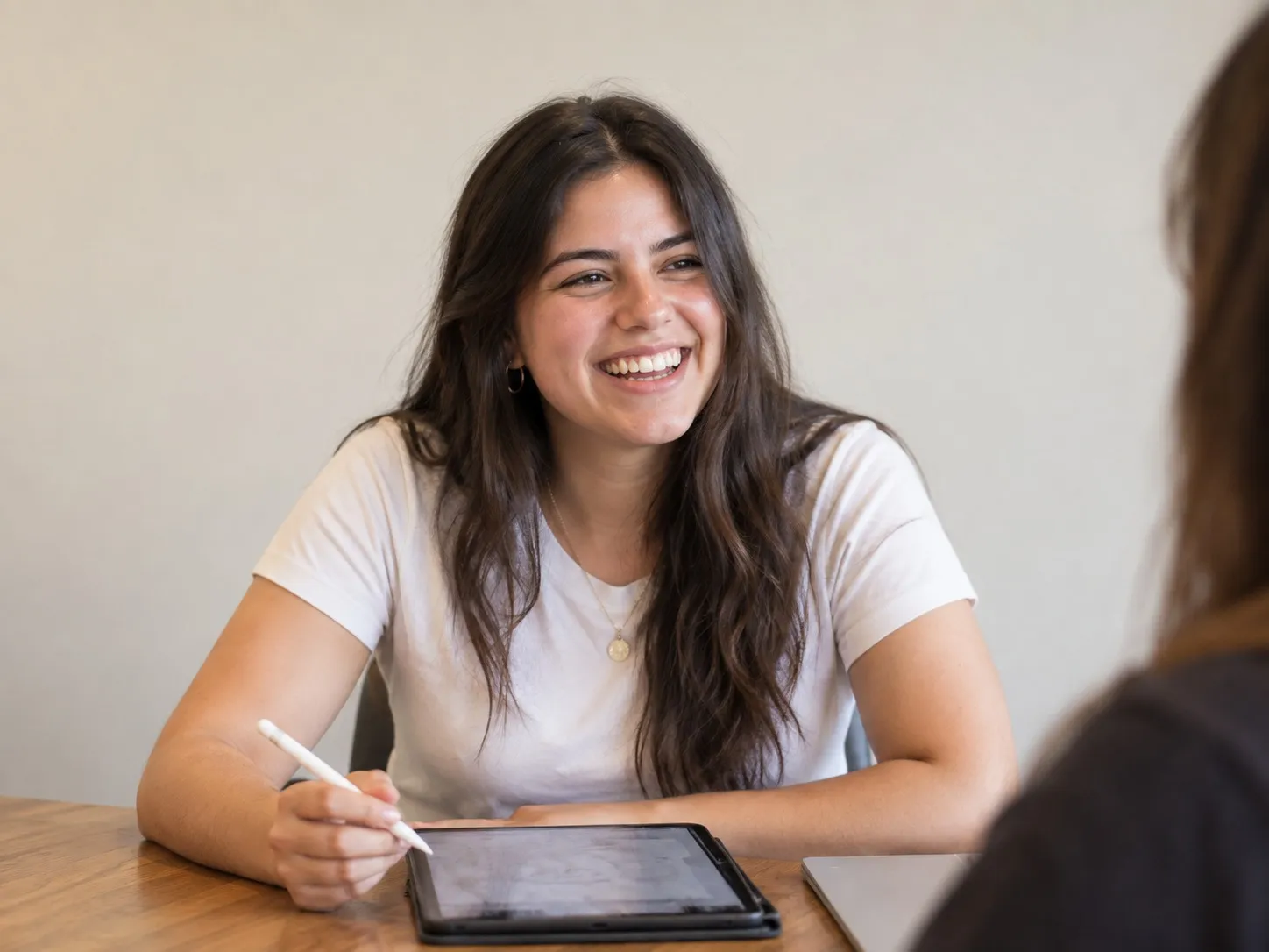 Estudiante sonriendo mientras trabaja en una tablet