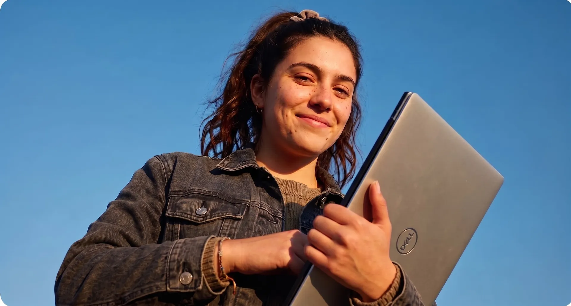 Estudiante con un computador, al aire libre